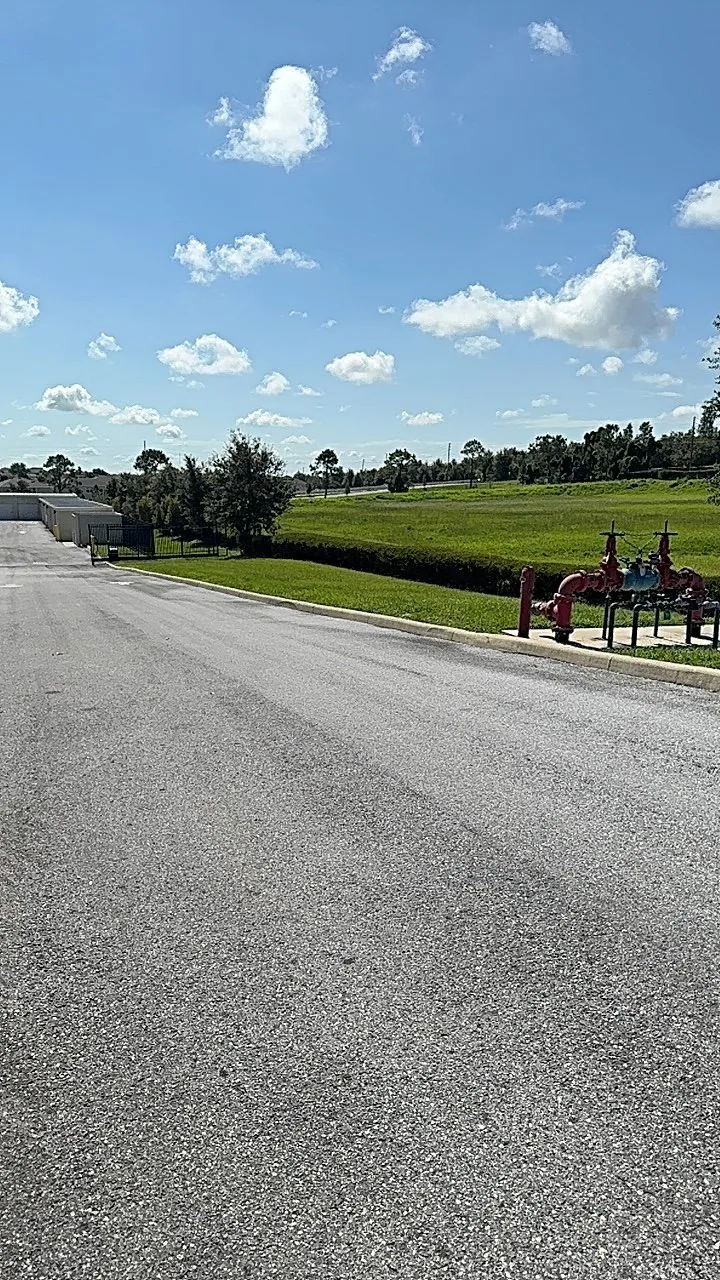 Wide commercial grounds with maintained turf beside a paved roadway