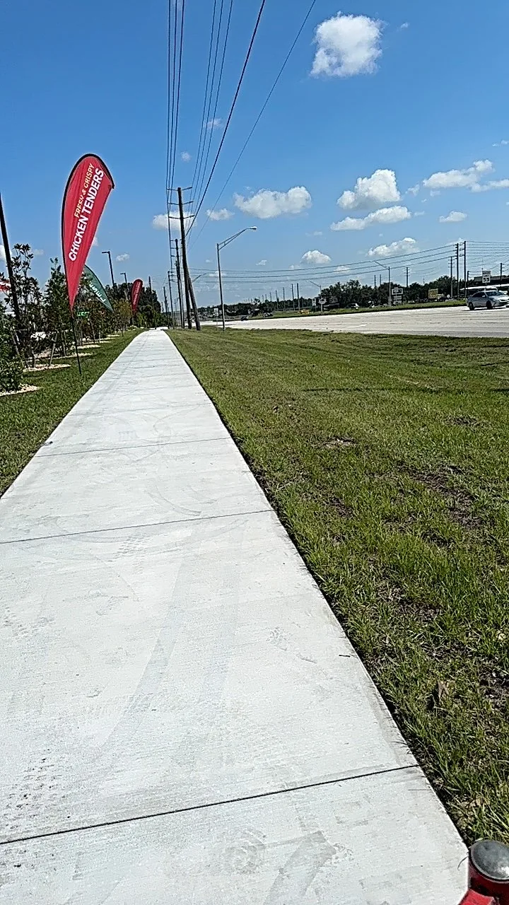 Freshly maintained commercial lawn beside a wide sidewalk