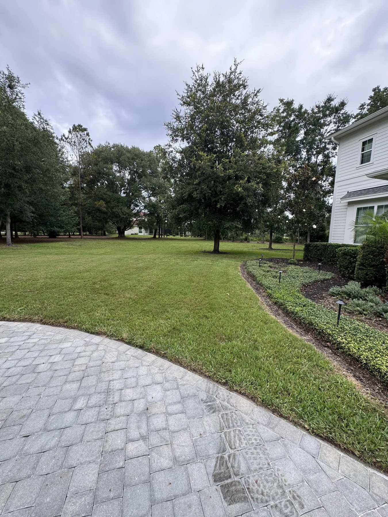 Expansive maintained front lawn beside a large residence