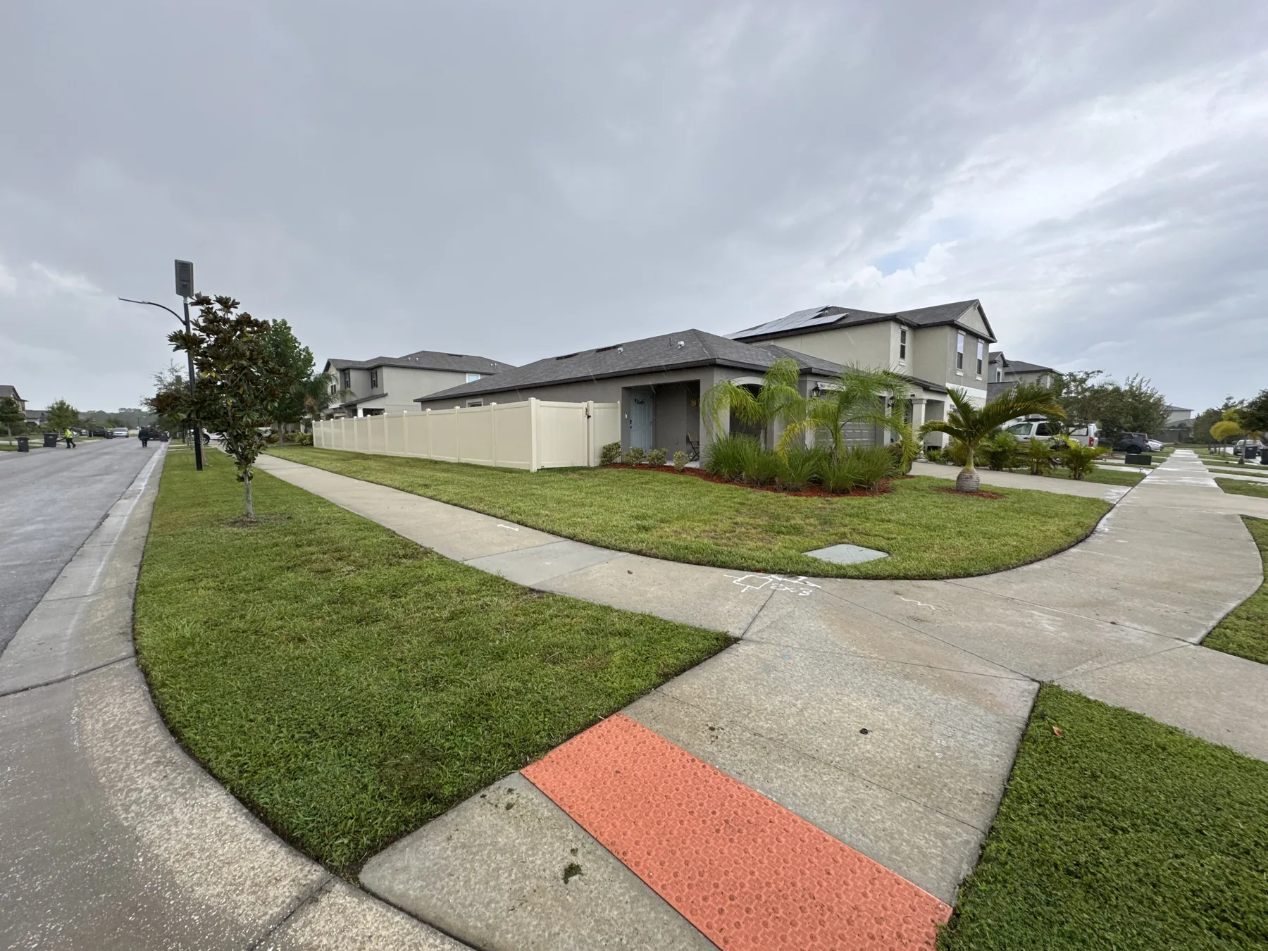 Maintained corner lawn wrapping around a residential sidewalk