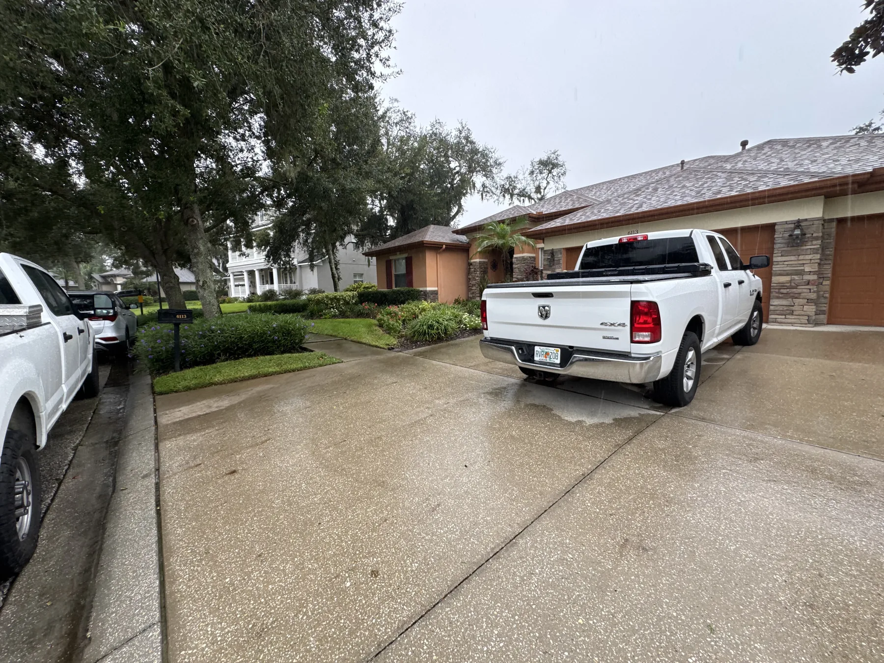 Clean driveway bordered by hedges and maintained turf